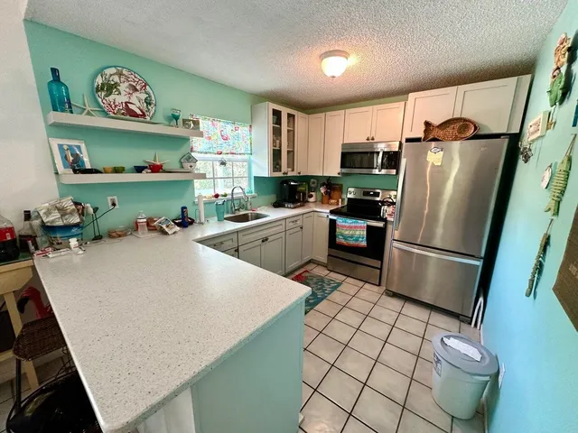 a kitchen with stainless steel appliances a refrigerator sink and a stove