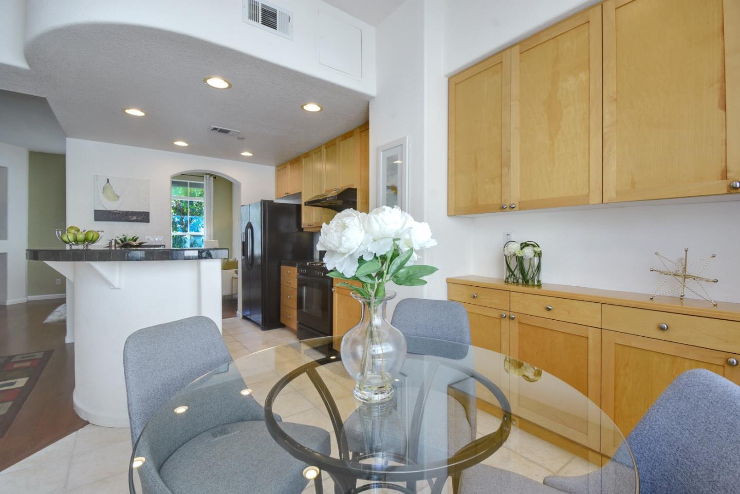 842 Wind Walk Milpitas, CA 95035 - Photo 13 of 45 a kitchen with stainless steel appliances granite countertop a refrigerator a sink a stove a dining table and chairs with wooden floor