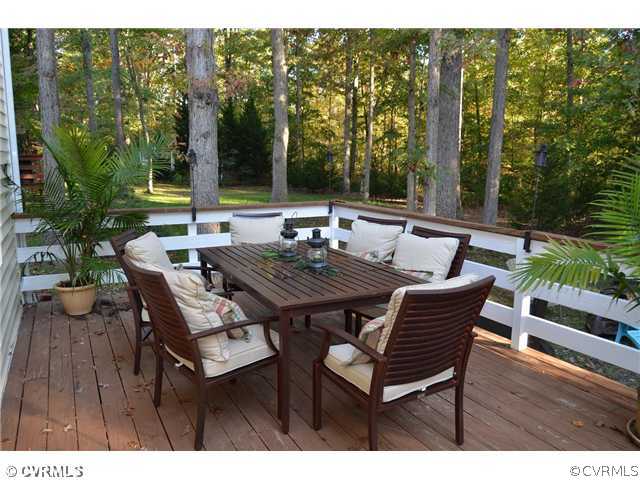 13802 Turtle Hill Road Midlothian, VA 23112 - Photo 11 of 12 a view of a backyard with table and chairs with wooden floor and fence