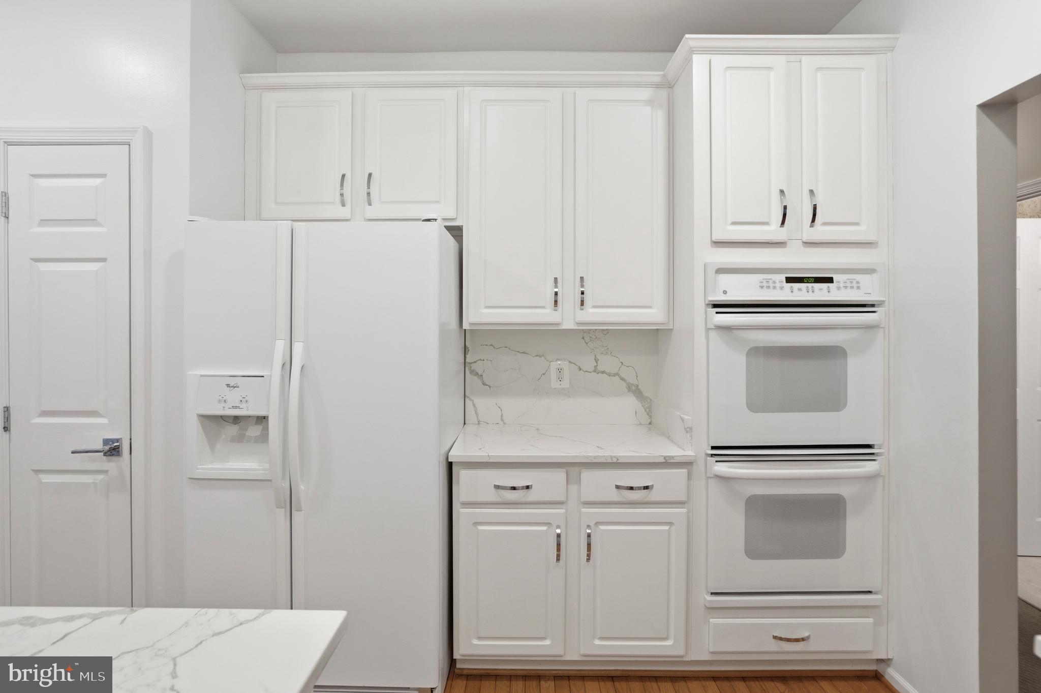 8941 Griffin Way, Unit 8941 Baltimore, MD 21208 - Photo 12 of 49 a kitchen with white cabinets and white appliances