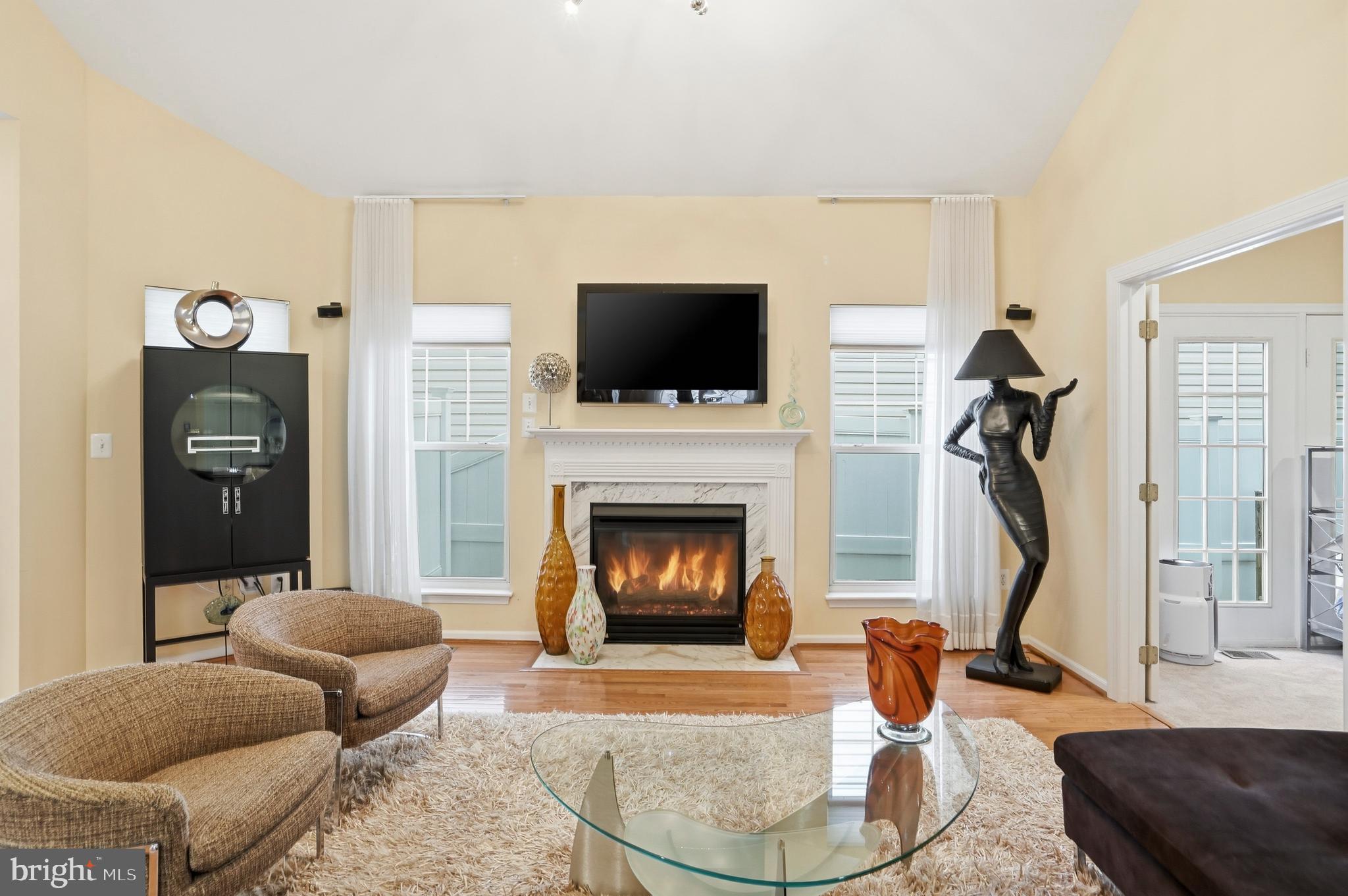 8941 Griffin Way, Unit 8941 Baltimore, MD 21208 - Photo 5 of 49 a living room with furniture a flat screen tv and a fireplace