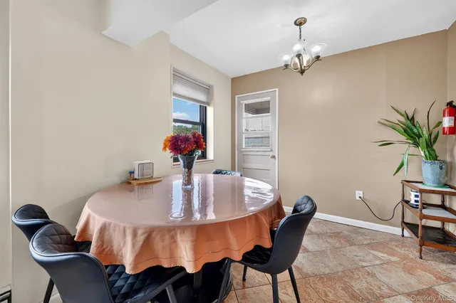 a view of a dining room with furniture a kitchen and chandelier
