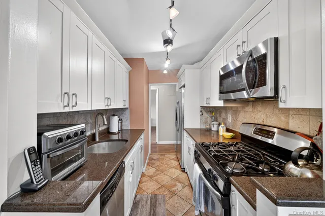 a kitchen with stainless steel appliances a stove a sink and cabinets