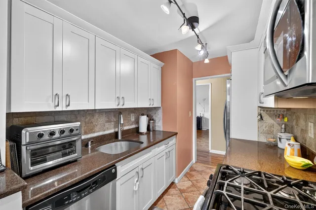 a kitchen with stainless steel appliances granite countertop a sink stove and cabinets