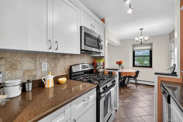 a kitchen with granite countertop a sink a stove and cabinets