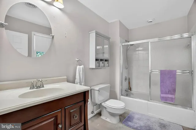 a bathroom with a sink a toilet a mirror and shower