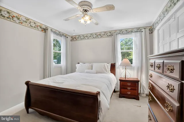a bedroom with a bed and a ceiling fan