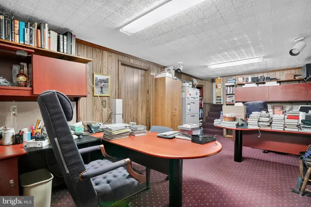 a view of a workspace with furniture and a book shelf