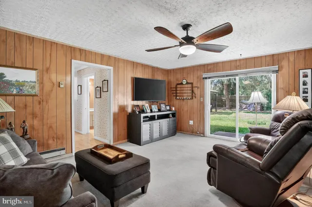 a living room with furniture a flat screen tv and a window