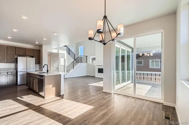 a view of a kitchen with wooden floor and a view of living room