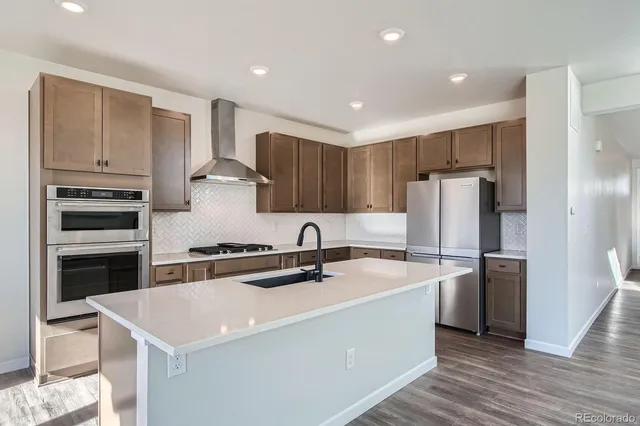 a kitchen with a white stove top oven and refrigerator