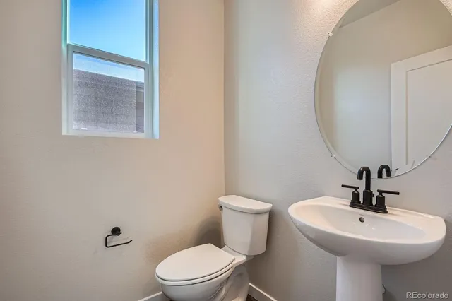 a bathroom with a toilet a sink and mirror