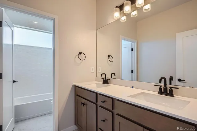 a bathroom with a sink a large mirror and a bathtub