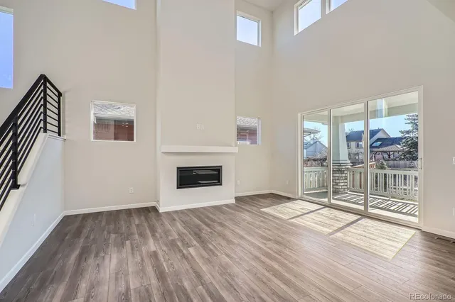 a view of empty room with wooden floor and fireplace