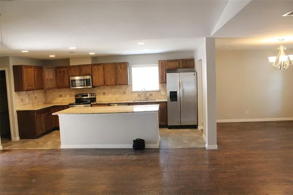 a view of kitchen with stainless steel appliances granite countertop a stove a sink and a refrigerator