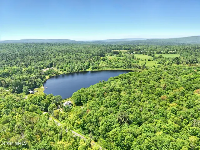 an aerial view of a house with a yard and lake view