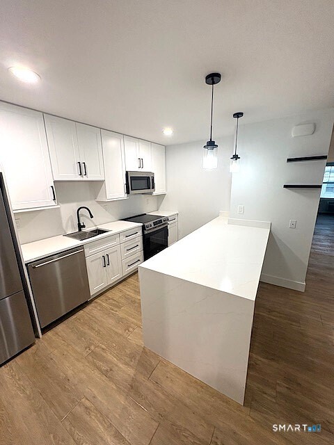 25 Church Street, Unit 301 New Milford, CT 06776 - Photo 2 of 14 a kitchen with kitchen island a sink stainless steel appliances and cabinets