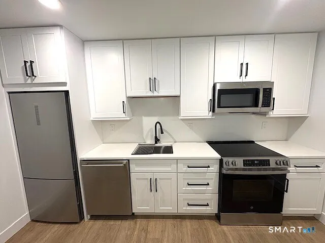 a kitchen with stainless steel appliances a stove a sink and a microwave