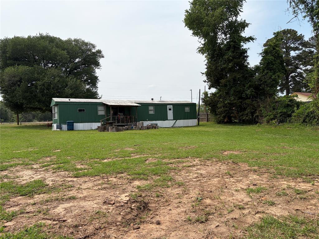 410 Patrick Street Minden, LA 71055 - Photo 3 of 9 Expansive green lot featuring a single-story residence with a covered porch and mature trees