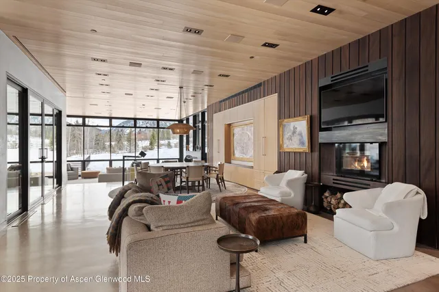 a living room with furniture kitchen view and a window