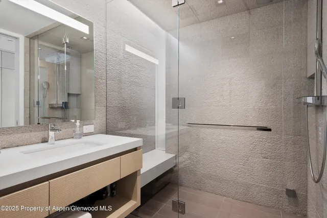 a bathroom with a shower sink and mirror