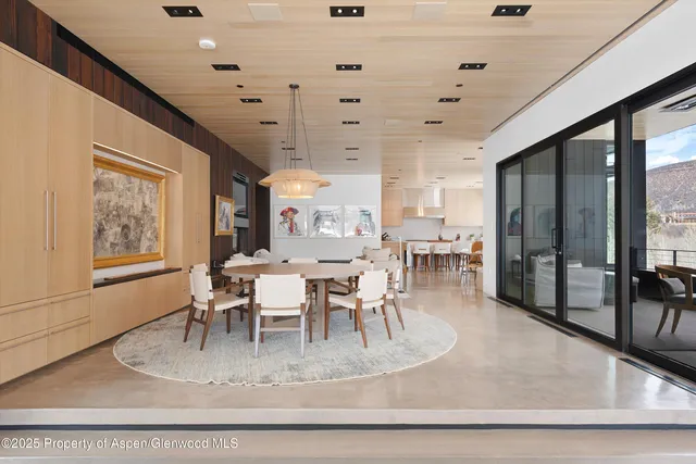 a view of a dining room with furniture a chandelier and wooden floor