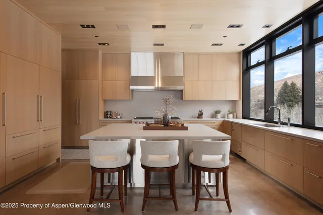 a kitchen with a stove a table and chairs in it
