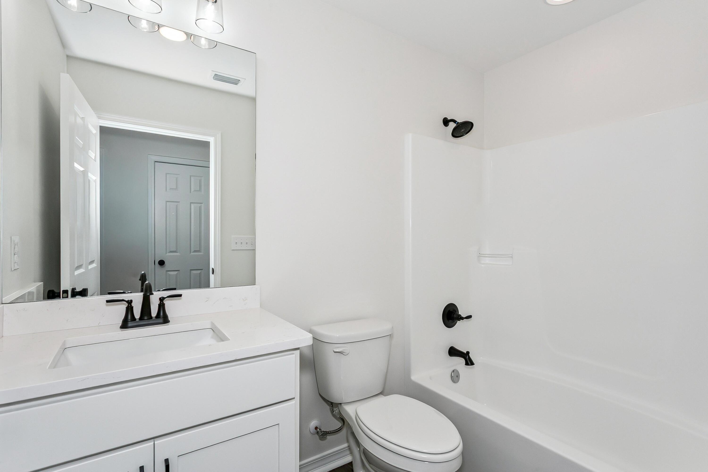 8084 3rd Street Laurel Hill, FL 32567 - Photo 26 of 34 a bathroom with a sink a toilet and shower