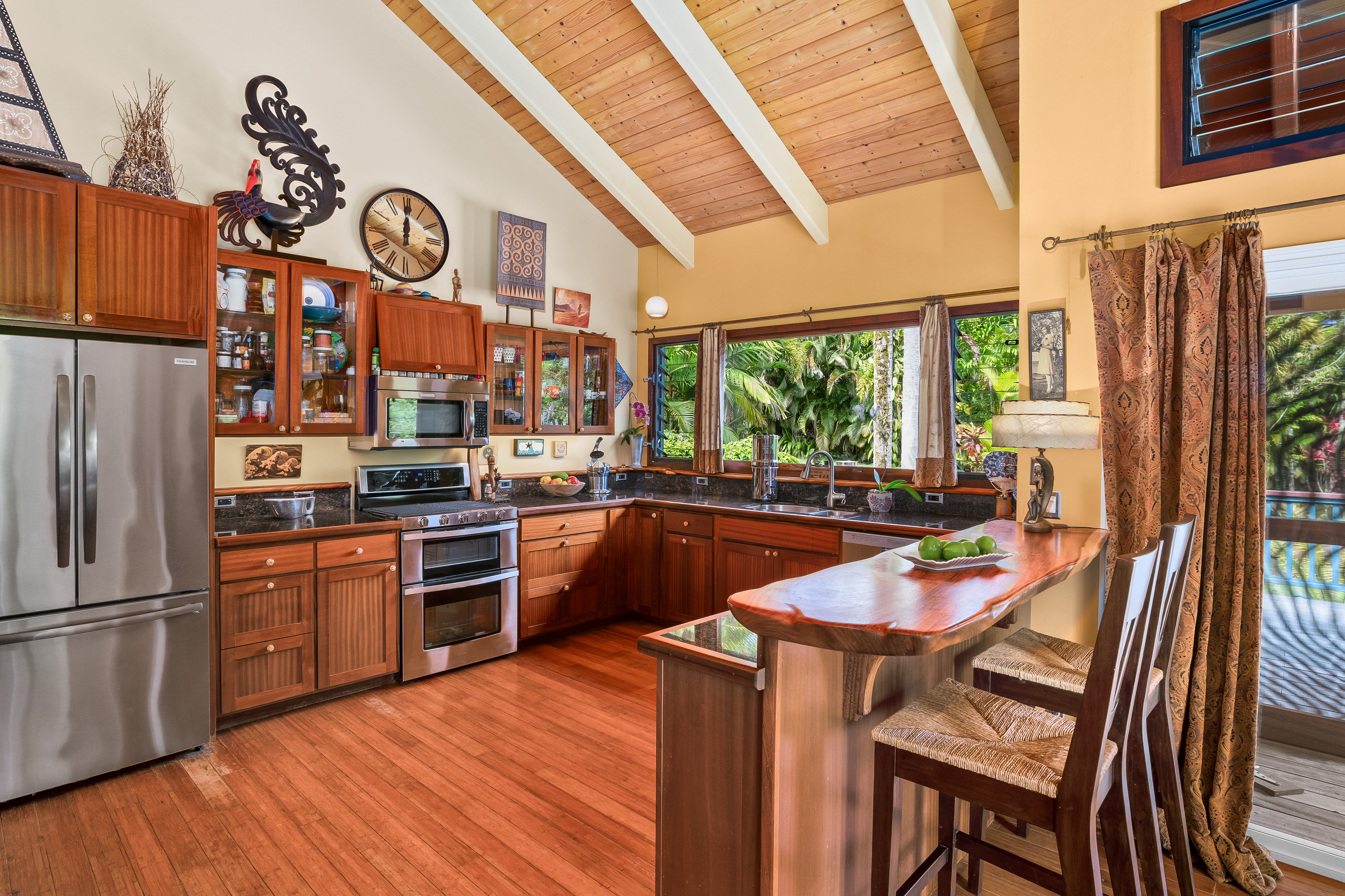 5728 Olohena Road Kapaa, HI 96746 - Photo 8 of 30 a kitchen with stainless steel appliances a stove a refrigerator a oven a kitchen island with a dining table and chairs