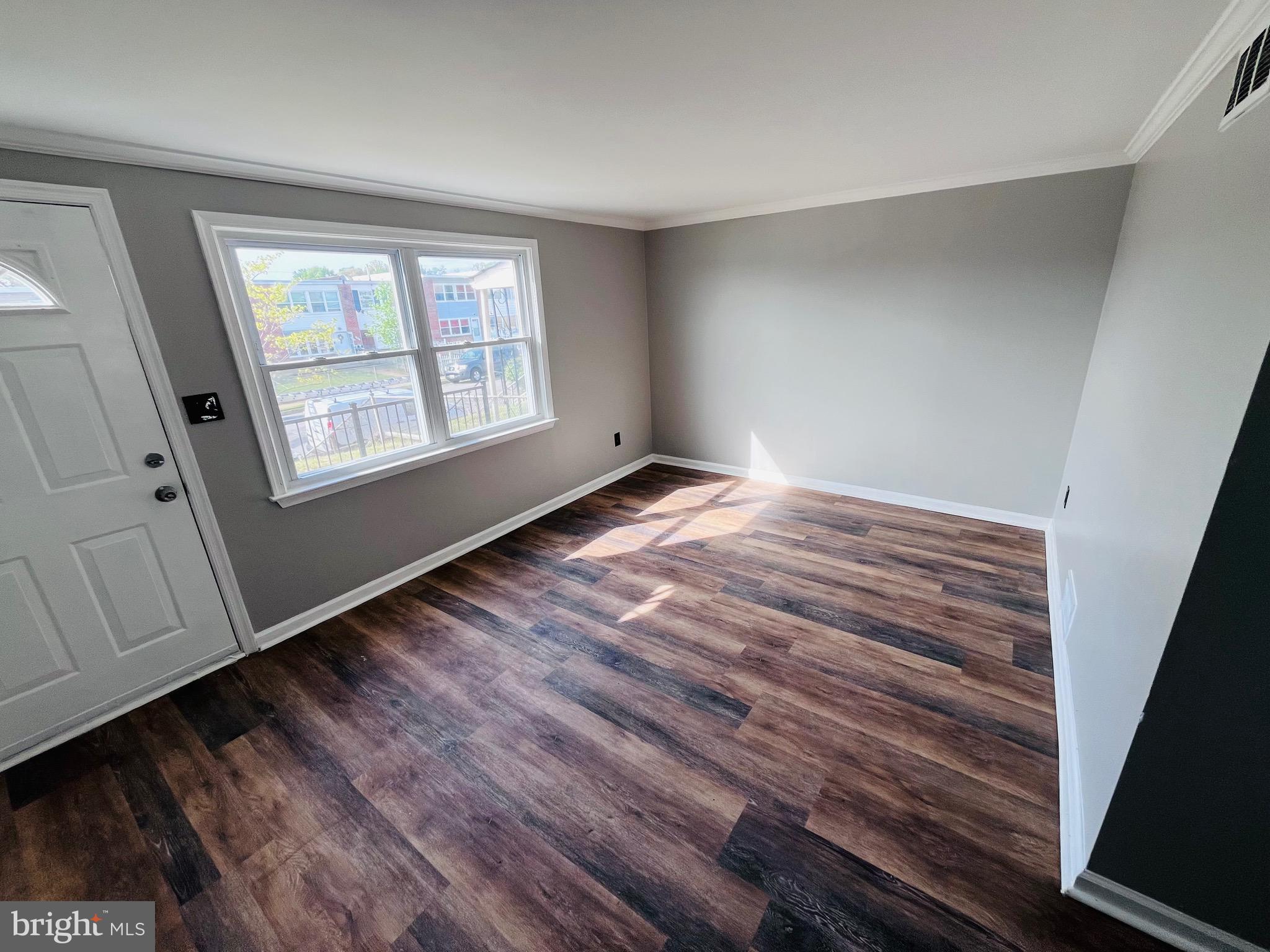 7932 Wynbrook Road Baltimore, MD 21224 - Photo 3 of 13 a view of an empty room with wooden floor and a window