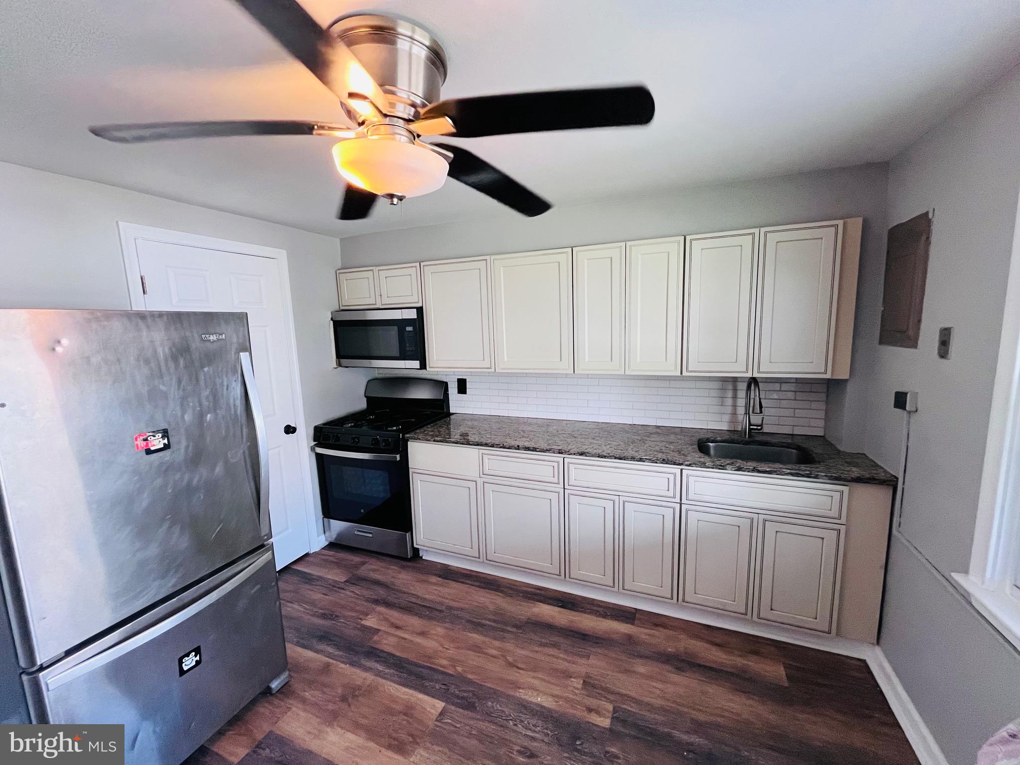 7932 Wynbrook Road Baltimore, MD 21224 - Photo 7 of 13 a kitchen with stainless steel appliances granite countertop a stove a sink and a refrigerator