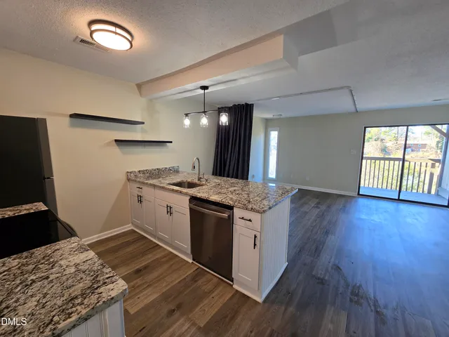 a kitchen with a stove wooden floor and a window