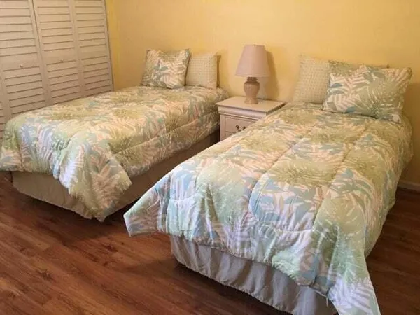 a bedroom with two beds and wooden floor