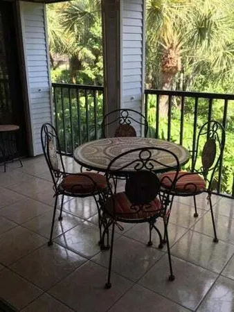 a view of a patio with table and chairs with wooden floor and fence