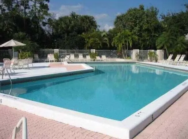 a view of a swimming pool with a table and chairs under an umbrella