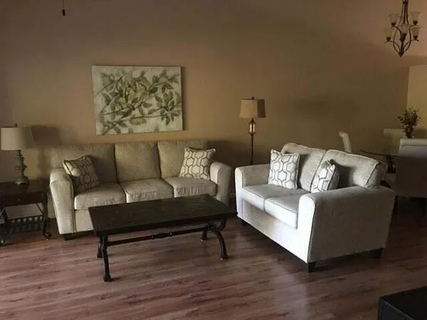 a living room with furniture and a wooden floor
