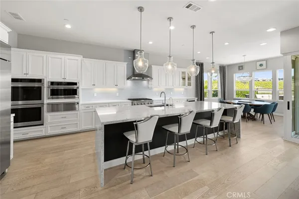 a kitchen with kitchen island granite countertop a sink a center island and cabinets
