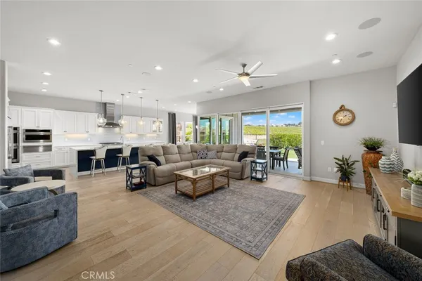 a living room with furniture flat screen tv and a large window
