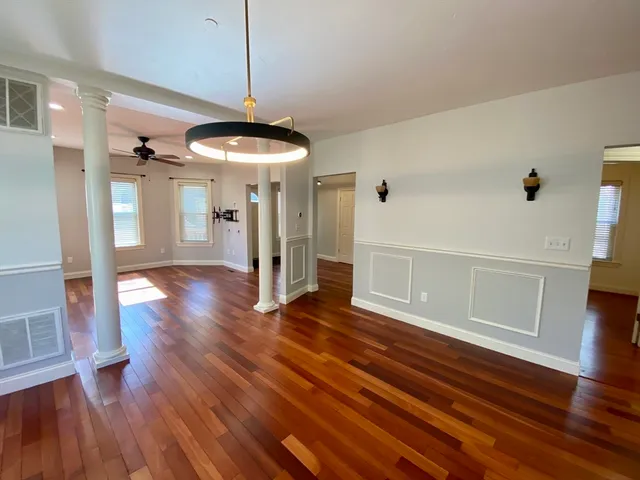 a view of a livingroom with wooden floor and a ceiling fan