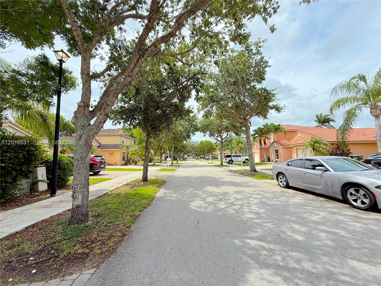 1575 Southeast 20th Road Homestead, FL 33035 - Photo 19 of 19 a view of a street with a building and trees in the background