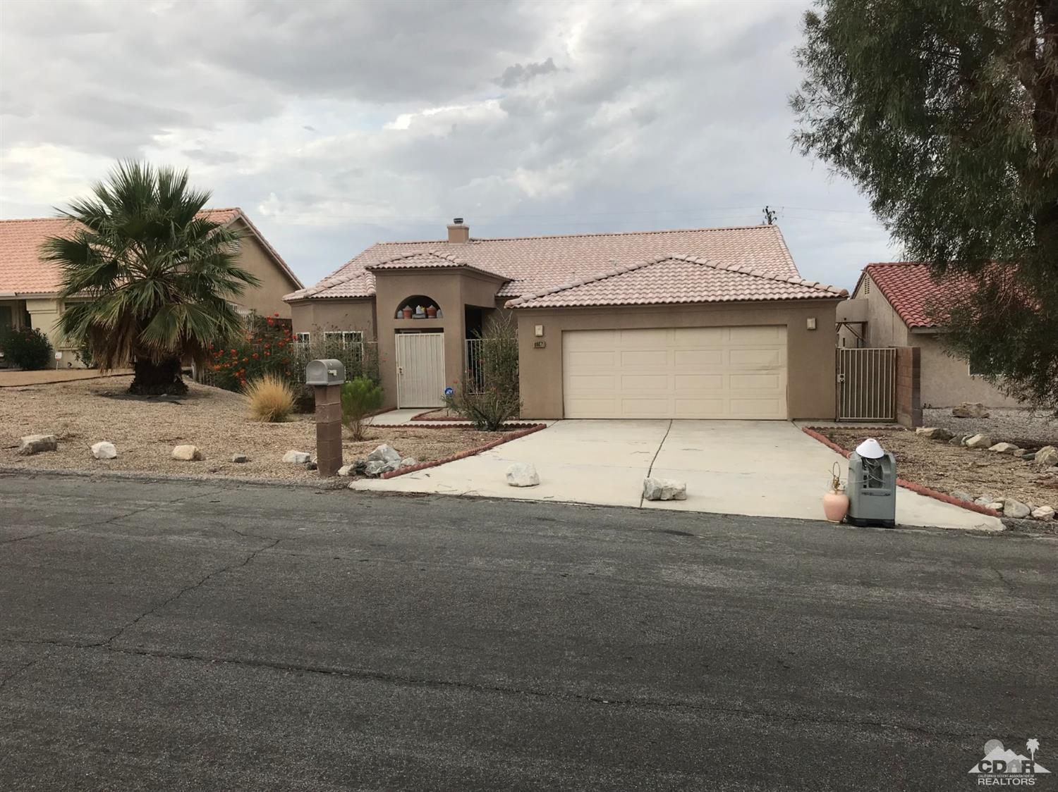 66071 Santa Rosa Road Desert Hot Springs, CA 92240 - Photo 3 of 15 a front view of a house with a yard and garage