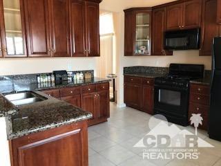66071 Santa Rosa Road Desert Hot Springs, CA 92240 - Photo 9 of 15 a kitchen with stainless steel appliances granite countertop a stove a sink and a microwave