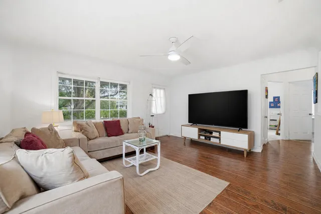 a kitchen with a refrigerator a stove a sink dishwasher and white cabinets with wooden floor