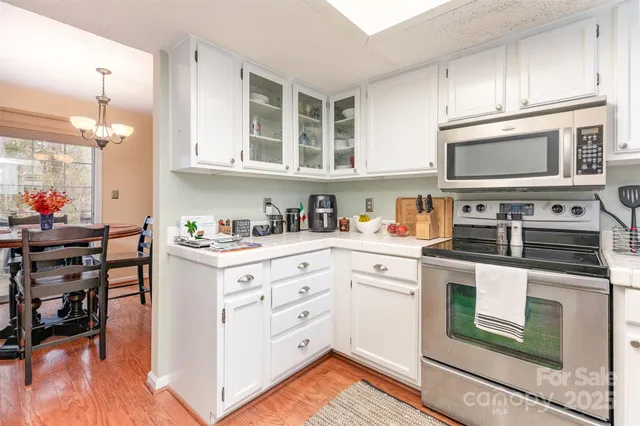 a kitchen with granite countertop cabinets stainless steel appliances and wooden floor