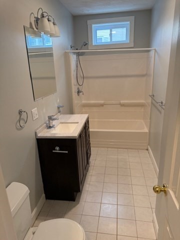 21 Sylvan Street, Unit 1 Worcester, MA 01603 - Photo 6 of 10 a bathroom with a sink a toilet and mirror