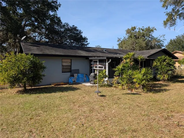 a view of the house with backyard space and trees