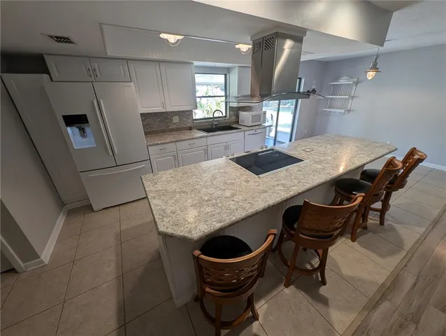 a kitchen with granite countertop a table chairs and stove