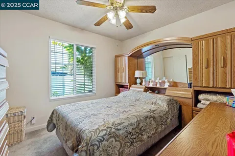 a spacious bedroom with a bed and dresser with mirror