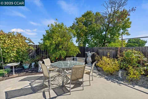 a view of a chairs and table in the backyard