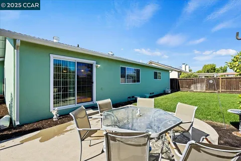 a view of a patio with table and chairs with plants and garden